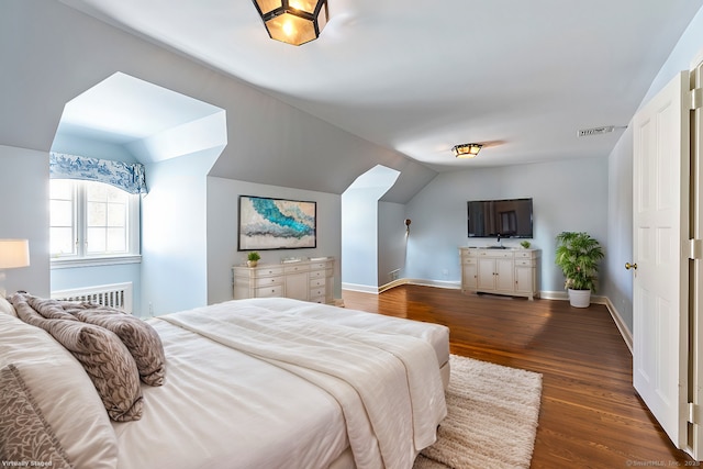 bedroom featuring lofted ceiling, radiator, and dark hardwood / wood-style floors