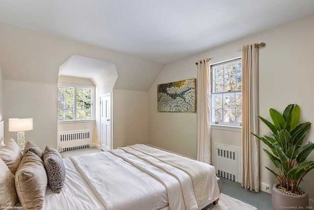 bedroom featuring lofted ceiling, carpet flooring, and radiator heating unit