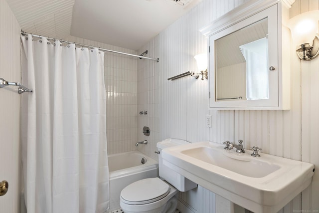 full bathroom featuring sink, shower / tub combo with curtain, and toilet