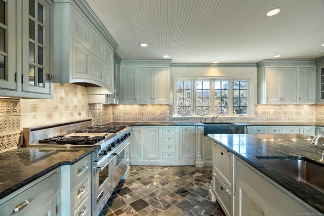 kitchen with tasteful backsplash, double oven range, sink, and dark stone counters