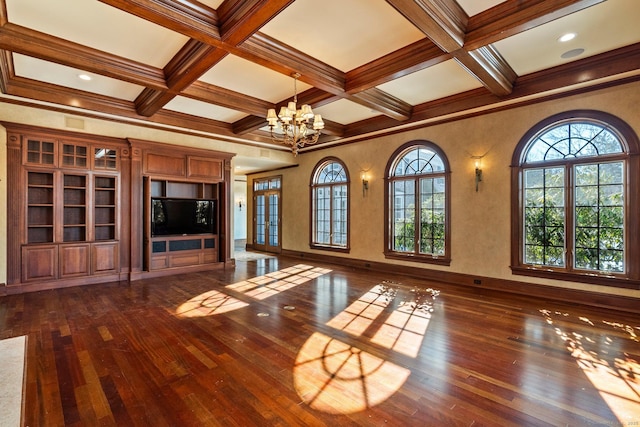 unfurnished living room featuring beamed ceiling, plenty of natural light, dark hardwood / wood-style floors, and an inviting chandelier