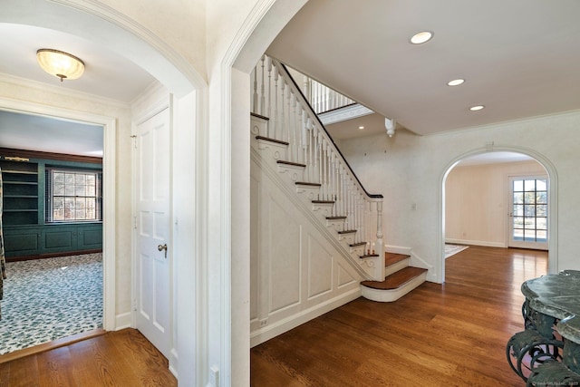 stairs featuring crown molding and hardwood / wood-style floors