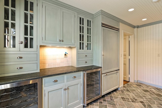 bar with wine cooler, backsplash, ornamental molding, and dark stone countertops