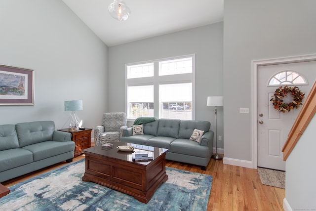 living room featuring light hardwood / wood-style flooring and high vaulted ceiling