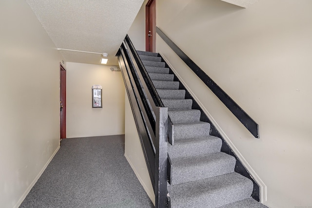 stairs with carpet flooring and a textured ceiling