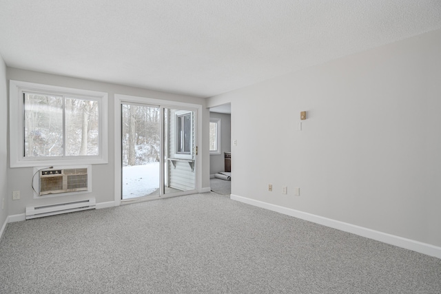 carpeted spare room featuring baseboard heating, a textured ceiling, and an AC wall unit