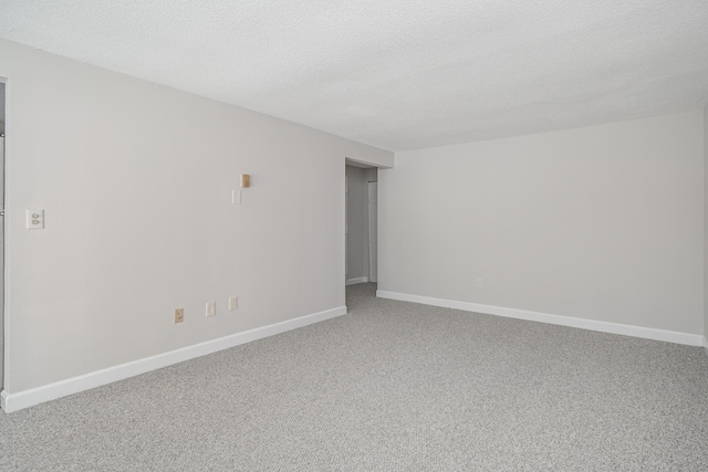 unfurnished room with carpet flooring and a textured ceiling