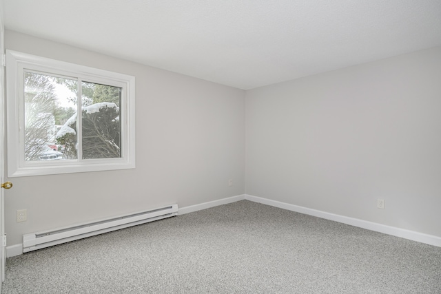 empty room with baseboard heating and carpet