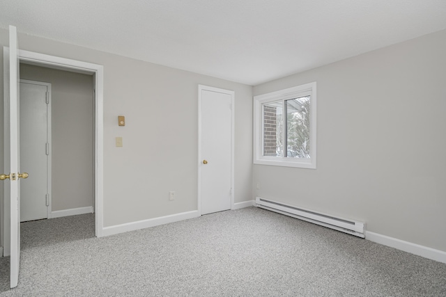 carpeted empty room featuring a baseboard radiator