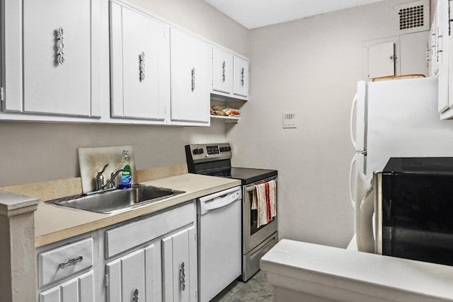 kitchen featuring sink, white cabinets, and white appliances