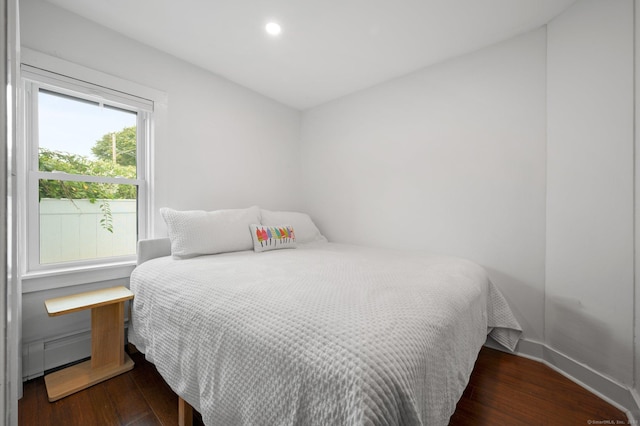 bedroom with dark hardwood / wood-style flooring and multiple windows