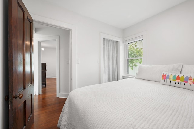 bedroom with dark hardwood / wood-style floors