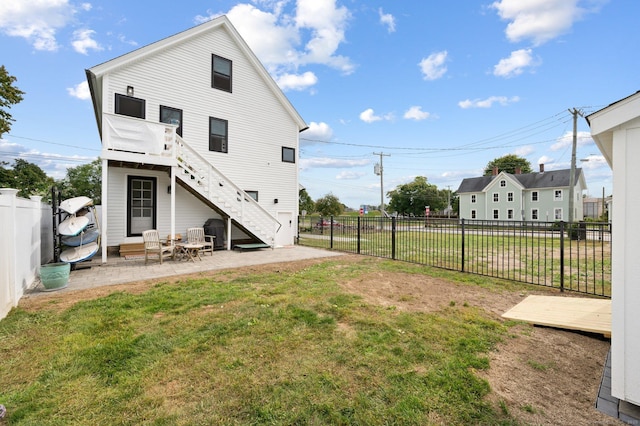 back of property with a yard and a patio area