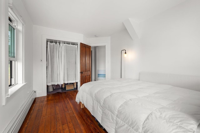 bedroom featuring dark hardwood / wood-style flooring, a baseboard radiator, and a closet