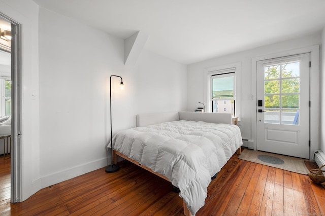 bedroom with a baseboard radiator, access to exterior, and hardwood / wood-style floors