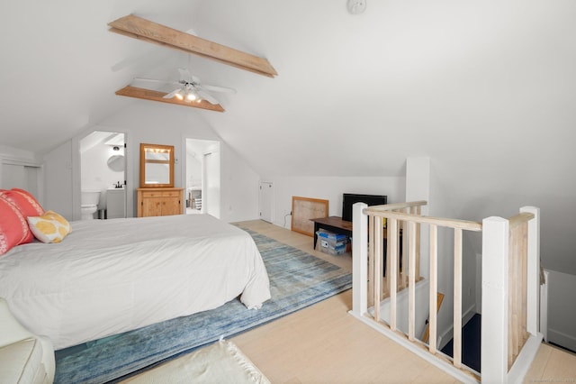 bedroom featuring connected bathroom, lofted ceiling with beams, ceiling fan, and light wood-type flooring