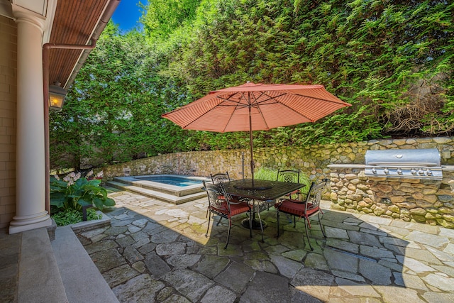 view of patio / terrace featuring exterior kitchen, an in ground hot tub, and area for grilling