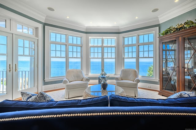 sunroom featuring a water view and french doors