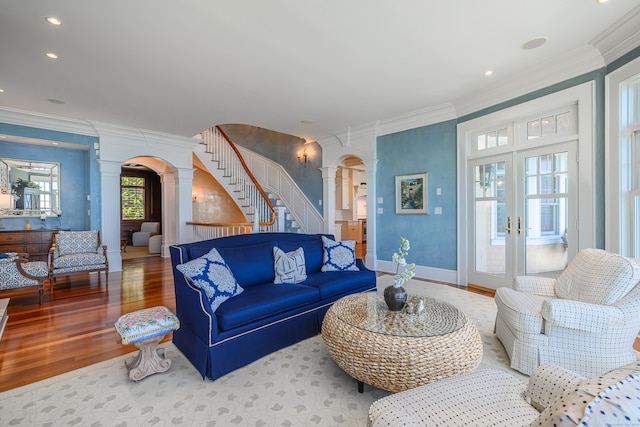 living room featuring crown molding, decorative columns, hardwood / wood-style floors, and french doors