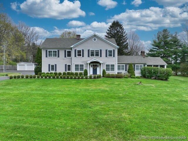 view of front of home with an outbuilding, a garage, and a front yard