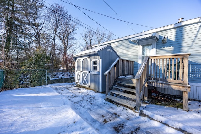 snow covered property with a shed