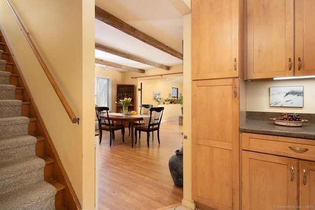 staircase with beamed ceiling and hardwood / wood-style floors