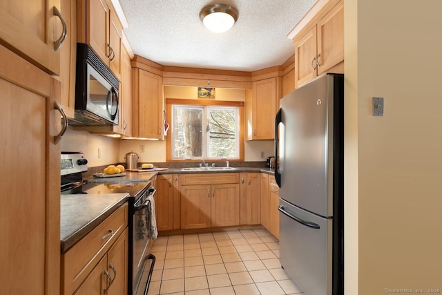 kitchen featuring stainless steel appliances, light tile patterned flooring, sink, and a textured ceiling