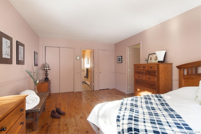 bedroom with connected bathroom, light hardwood / wood-style floors, and a closet