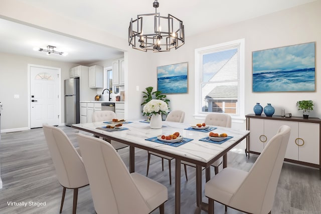 dining area with sink, a chandelier, and hardwood / wood-style floors