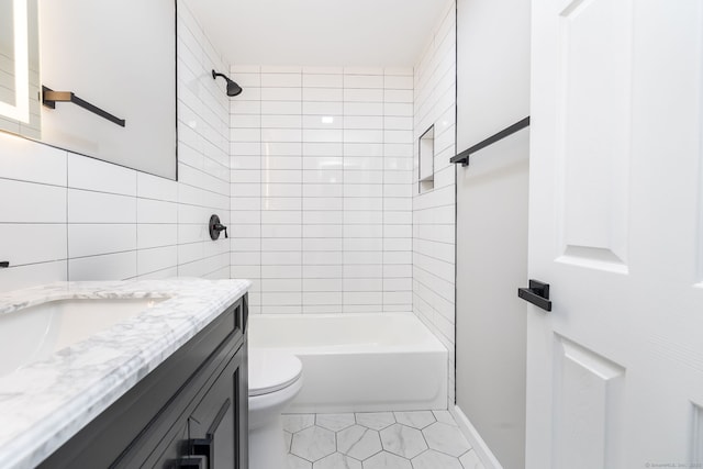 full bathroom featuring tiled shower / bath combo, vanity, tile walls, and toilet