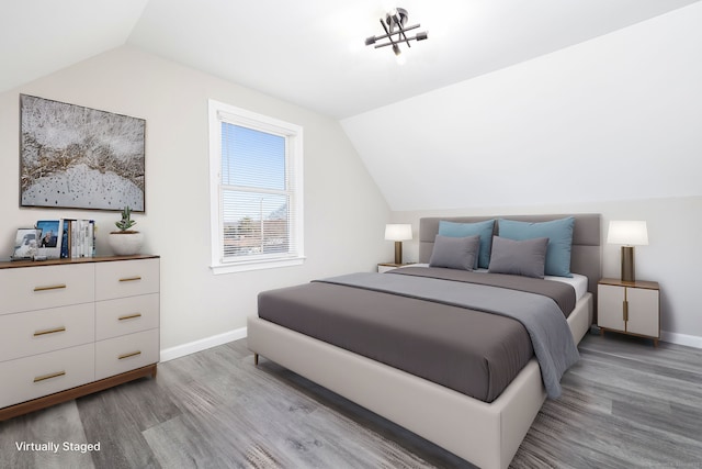 bedroom featuring lofted ceiling and hardwood / wood-style floors