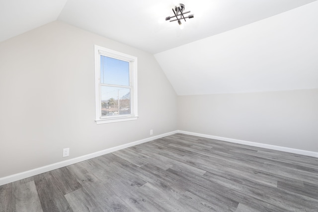 additional living space featuring hardwood / wood-style flooring and vaulted ceiling