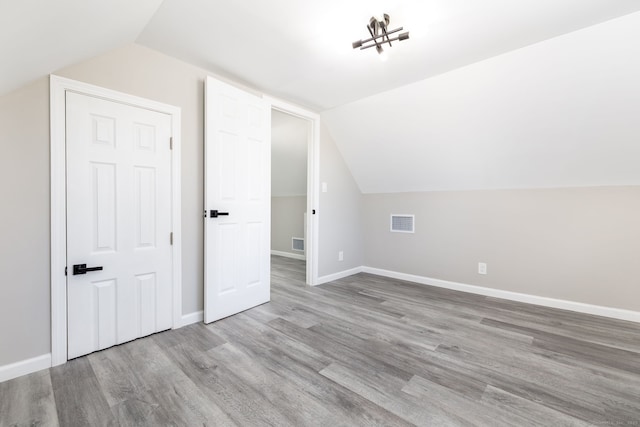 bonus room featuring lofted ceiling and light wood-type flooring