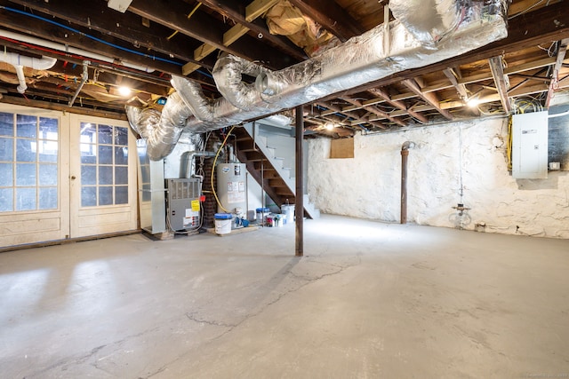 basement with heating unit, gas water heater, and electric panel