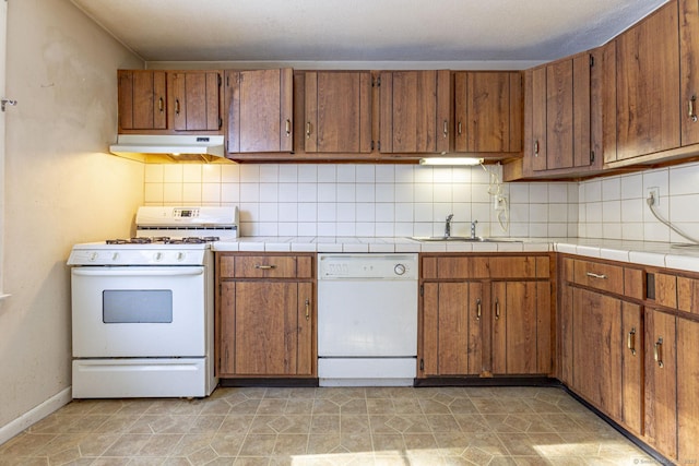 kitchen with sink, white appliances, and decorative backsplash