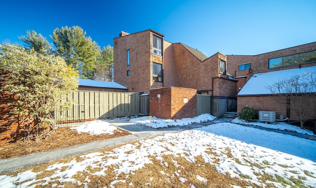 snow covered property with cooling unit