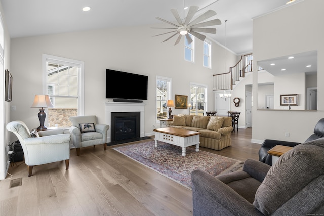 living room featuring ceiling fan, high vaulted ceiling, and light wood-type flooring