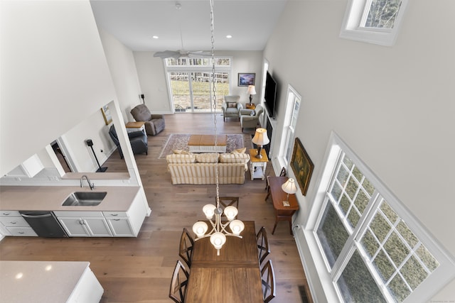 living room with hardwood / wood-style flooring, sink, and a towering ceiling