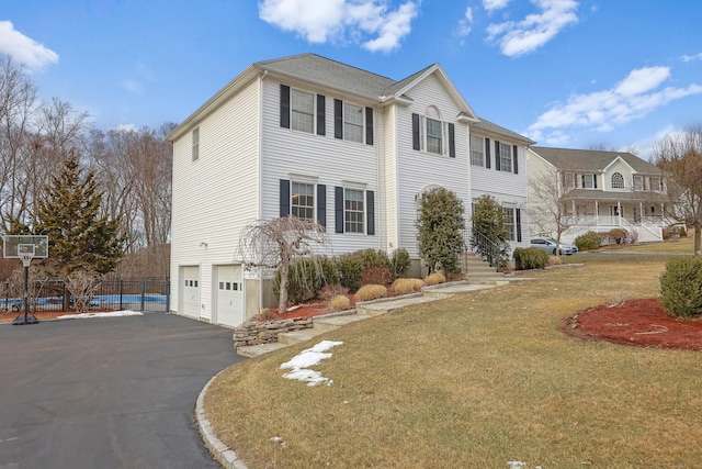 view of front of property with a garage and a front lawn