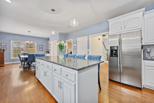 kitchen featuring white cabinetry, decorative light fixtures, and stainless steel fridge with ice dispenser