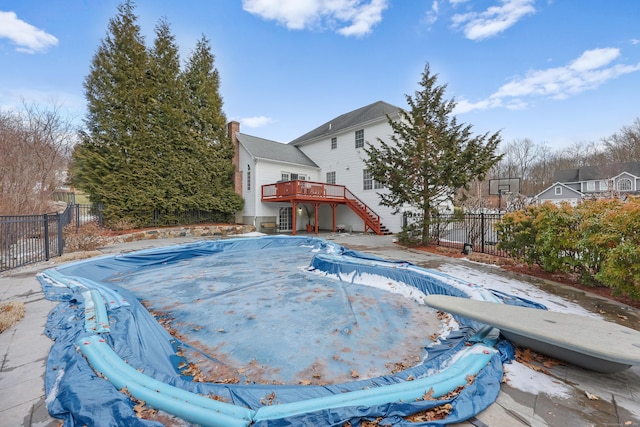 view of pool with a diving board and a deck