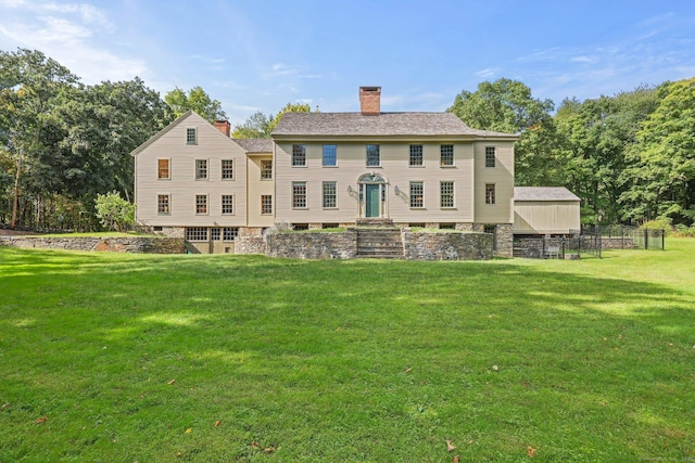 rear view of property featuring a lawn