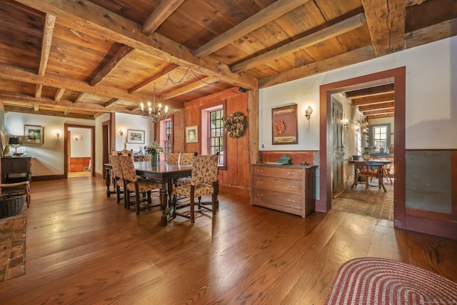 dining space featuring a notable chandelier, wood-type flooring, beam ceiling, and wooden ceiling