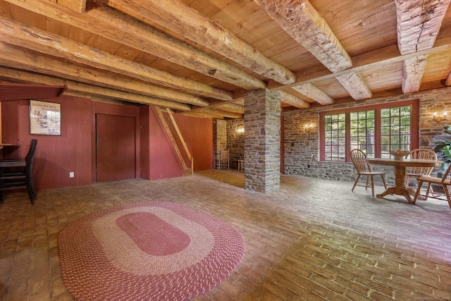 unfurnished living room featuring ornate columns, beam ceiling, and wooden ceiling