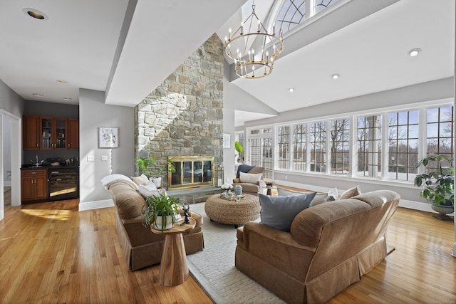 living room with plenty of natural light, a fireplace, light wood finished floors, and wine cooler