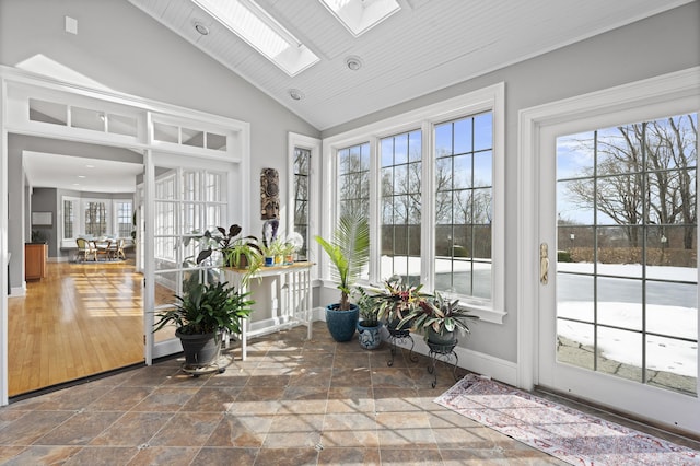 sunroom featuring lofted ceiling with skylight and a wealth of natural light