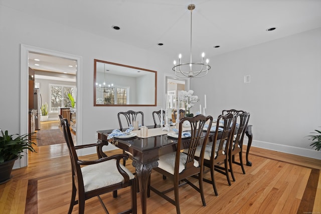 dining room featuring light wood finished floors, an inviting chandelier, recessed lighting, and baseboards