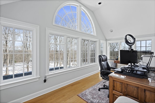 office area featuring high vaulted ceiling, light wood-type flooring, and baseboards