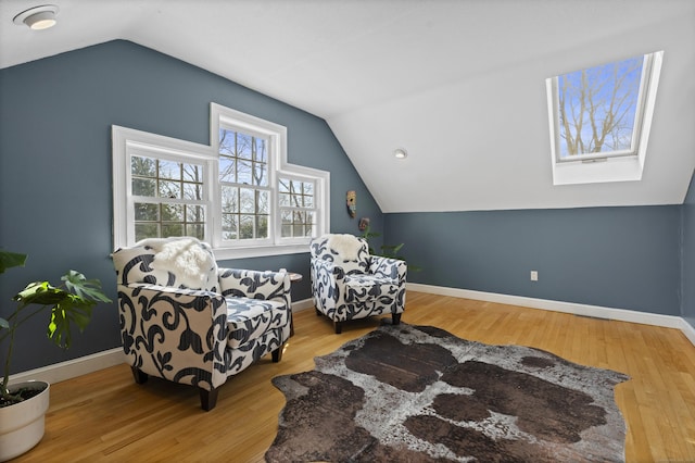 sitting room featuring baseboards, vaulted ceiling, and wood finished floors