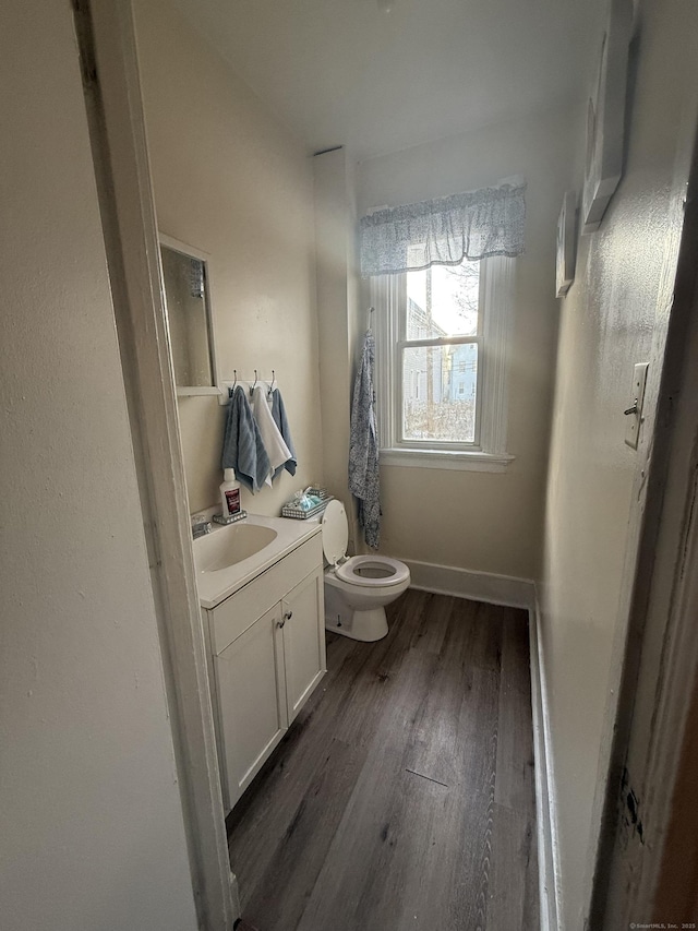 bathroom featuring wood-type flooring, toilet, and vanity